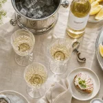 Vin blanc sec apéro : verres, seau à glace et amuse-bouches